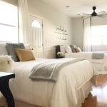 bedroom with two beds, white bedding and wood floor