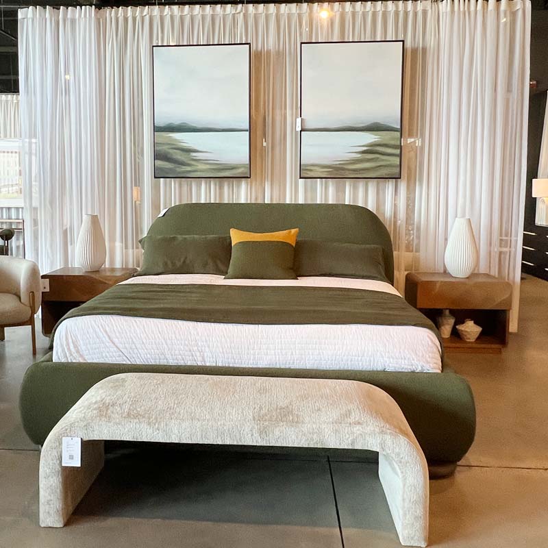 curtain behind upholstered bed with artwork