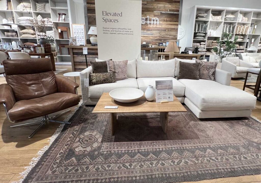 ivory sofa with brown rug and pillows